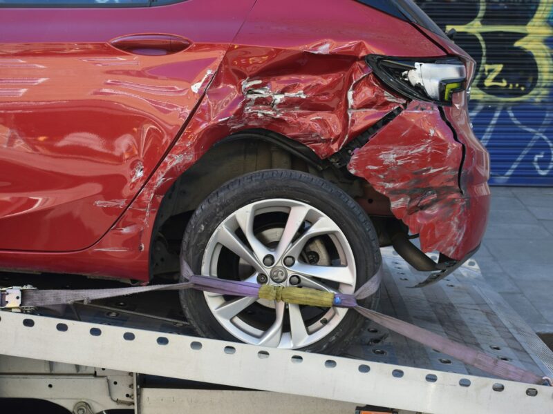 a red car is on a flatbed tow truck