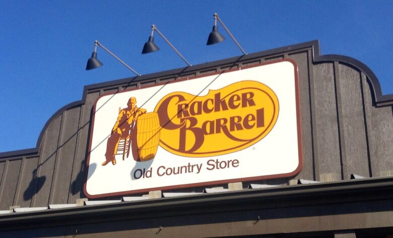 Cracker Barrel Old Country Store sign on a building against a blue sky.