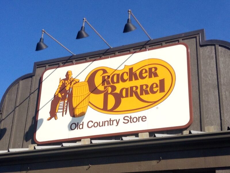 Cracker Barrel Old Country Store sign on a building against a blue sky.