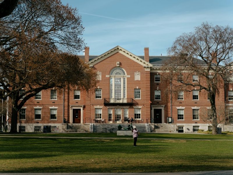 a person standing in front of a large brick building
