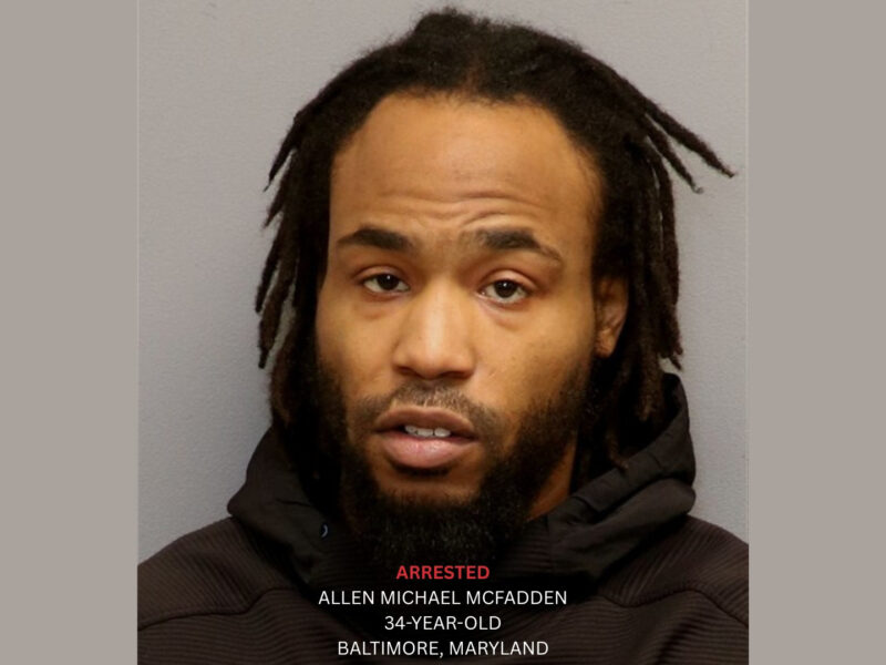 Mugshot of a man in a dark hoodie against a plain background with arrest text overlay.