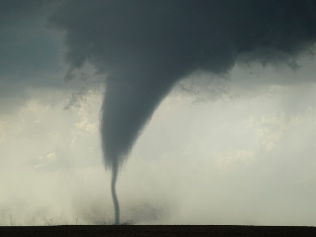 a large tornado is coming out of a field