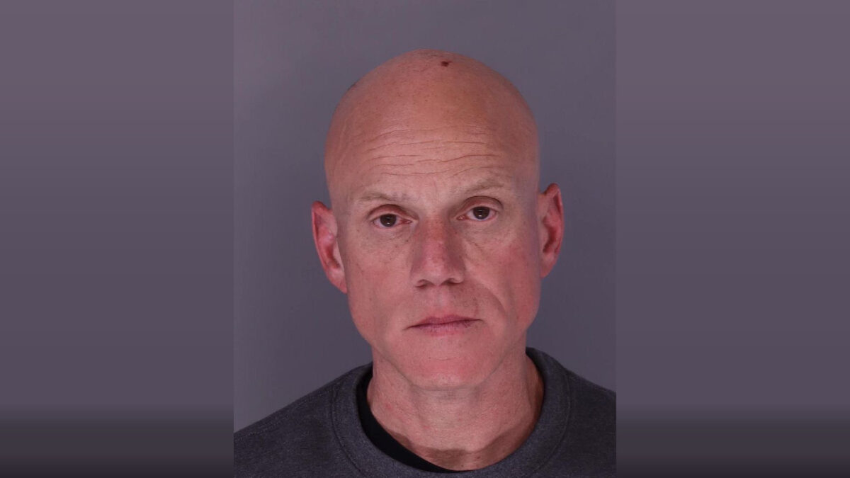Portrait of a bald man against a plain gray background with a neutral expression.
