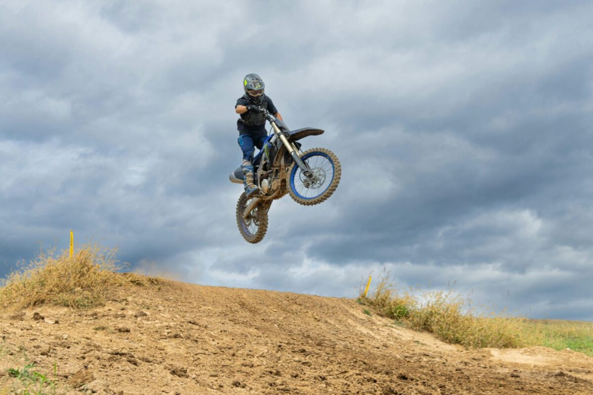 A thrilling dirt bike jump on a cloudy day in Pennsylvania, showcasing off-road adventure.