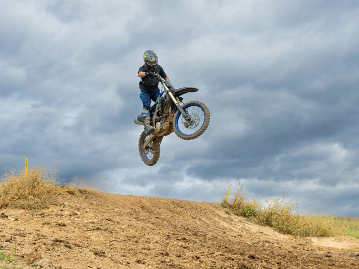 A thrilling dirt bike jump on a cloudy day in Pennsylvania, showcasing off-road adventure.