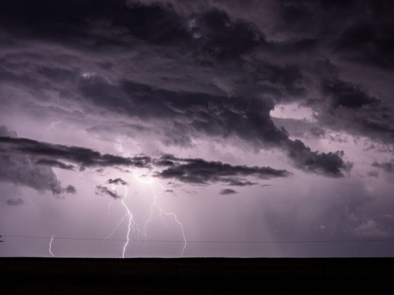 Dramatic stormy sky with intense lightning strikes illuminating dark clouds.