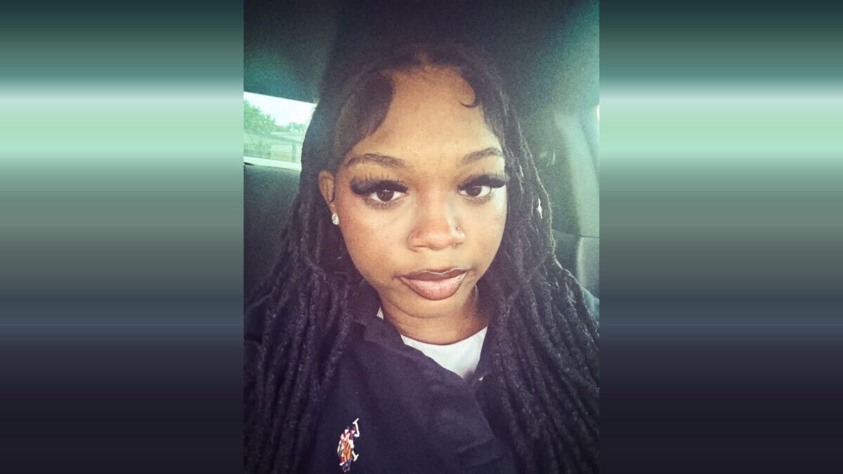 Selfie of a woman with long braids sitting in a car, wearing a black top.