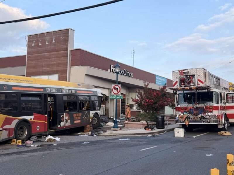 Fire truck and city bus after a street collision outside a FedEx Office store.