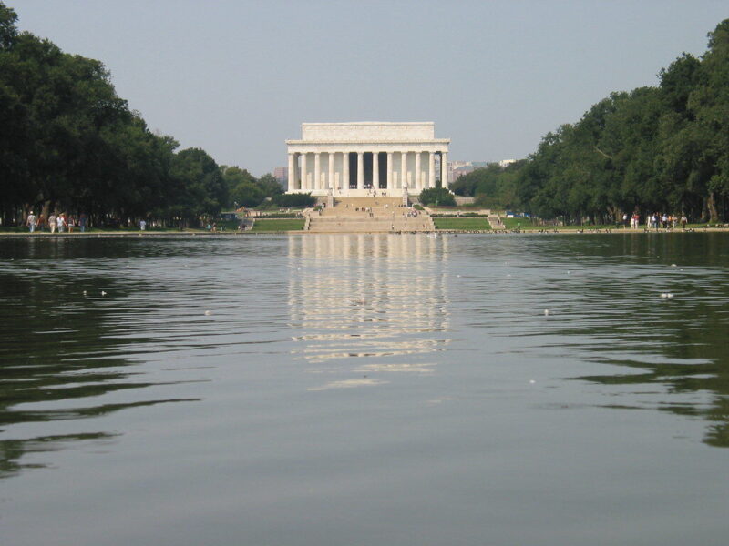 Lincoln Memorial across the Reflecting Pool with trees framing the Washington, D.C. landmark