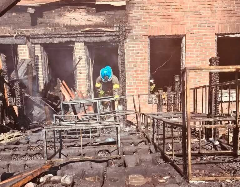 Firefighter works amid the charred remains of a burned building