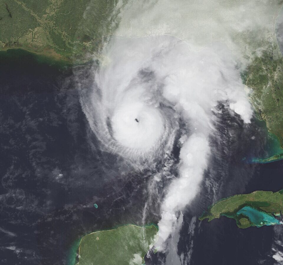 Satellite view of a swirling hurricane over ocean and coastline