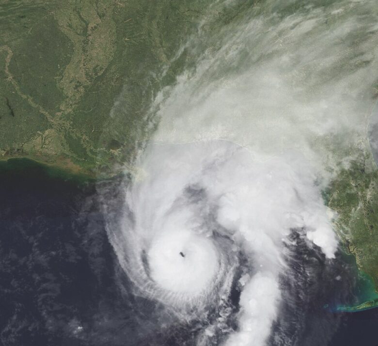 Satellite view of a swirling hurricane over ocean and coastline