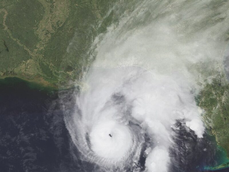 Satellite view of a swirling hurricane over ocean and coastline